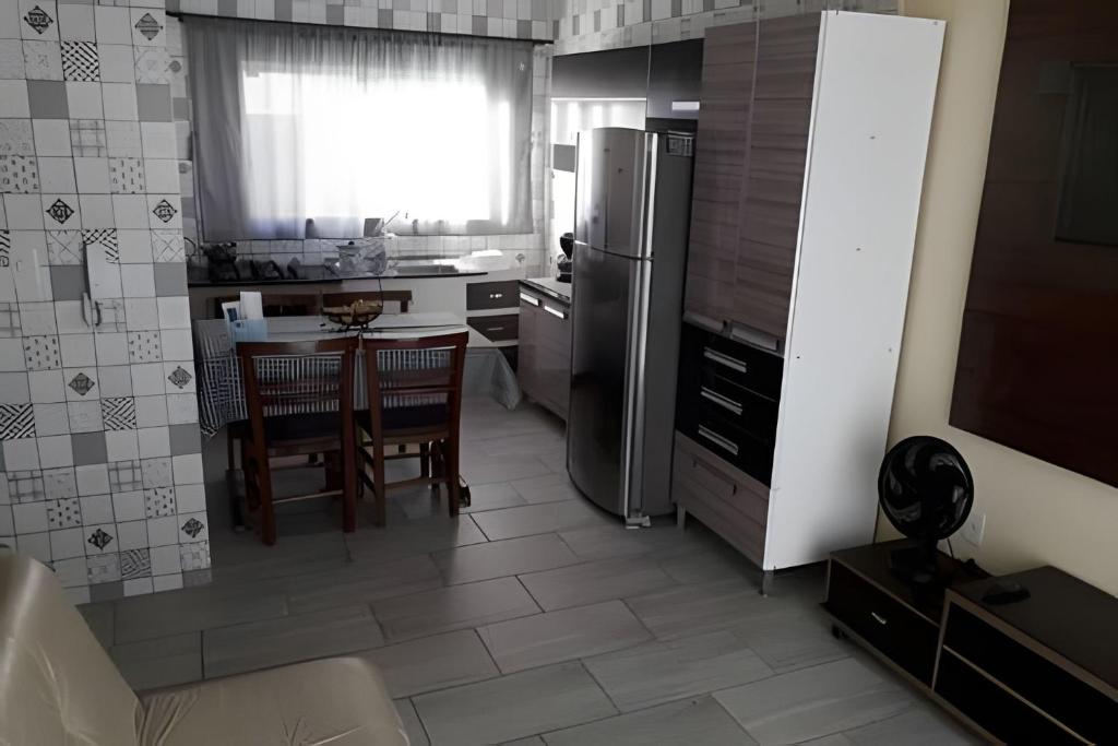 uma cozinha com uma mesa e um frigorífico de aço inoxidável em Apartamentos em SC em Itajaí