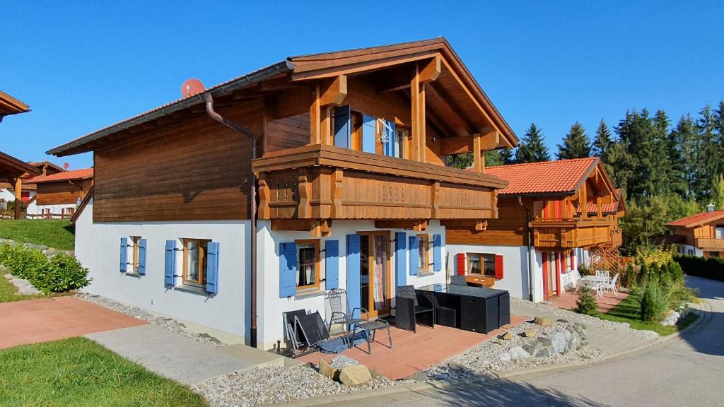 Lechbruck am See Feriendorf Via Claudia Haus 65 Casa Bavaria في ليتشبروك: منزل خشبي كبير ذو سقف مثلثي