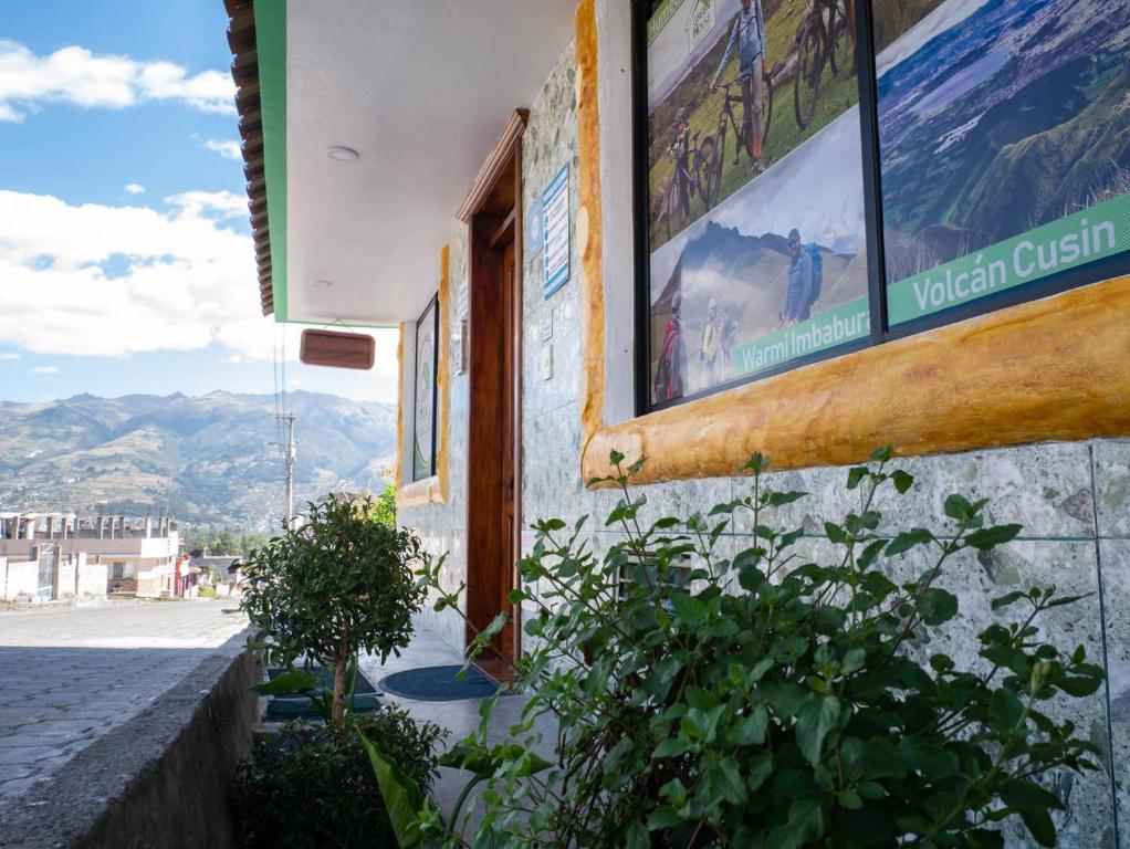 a building with a sign on the side of it at Green House Araque Inn in Otavalo