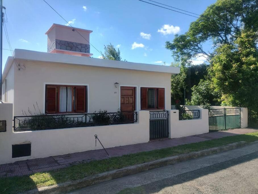 Una casa blanca con un faro encima. en Encantadora Casa con parque en La Falda