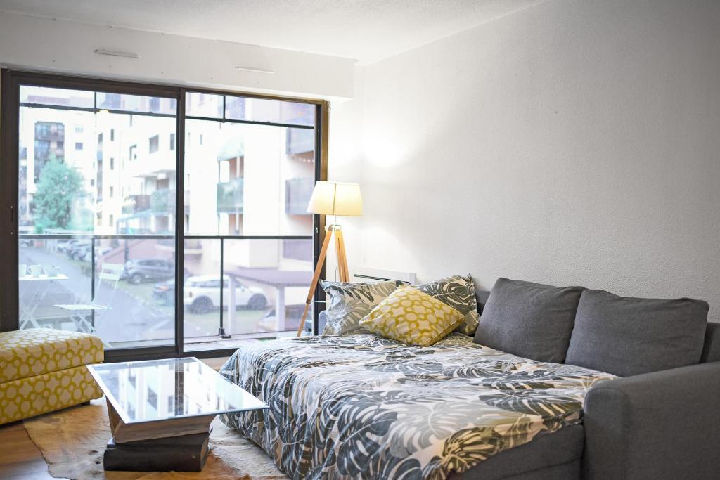 un salon avec un canapé et une table en verre dans l'établissement T2 dans résidence, Terrasse privée et Parking, à Toulouse