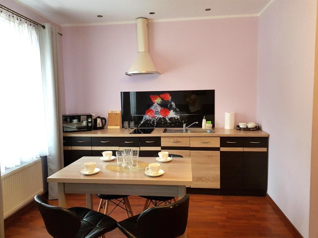 W Samiuśkim Centrum في شتوروك: مطبخ مع طاولة مع كراسي وتلفزيون