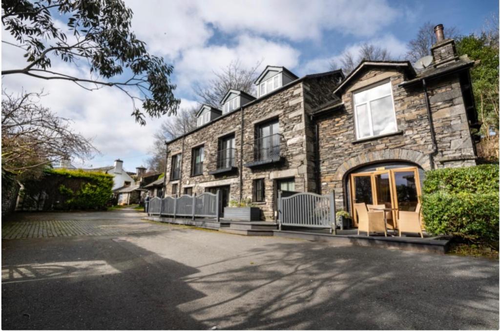 a large stone house with a driveway at Yewfield Self Catering Apartments in Hawkshead