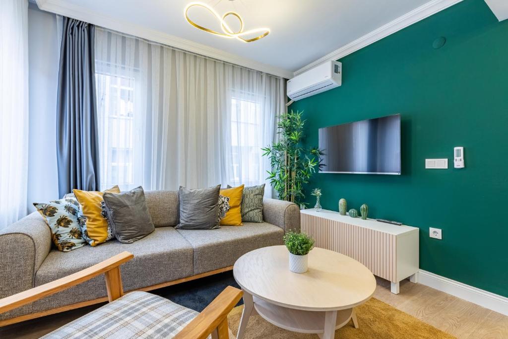 a living room with a couch and a green wall at Balat Apartments-Orange and Blue in Istanbul