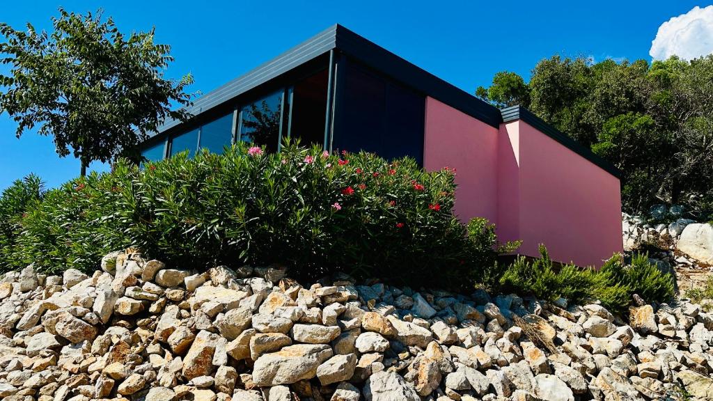 une maison au sommet d'un tas de rochers dans l'établissement Luxury Mobile Home Kasthouse Oleander, à Mali Lošinj