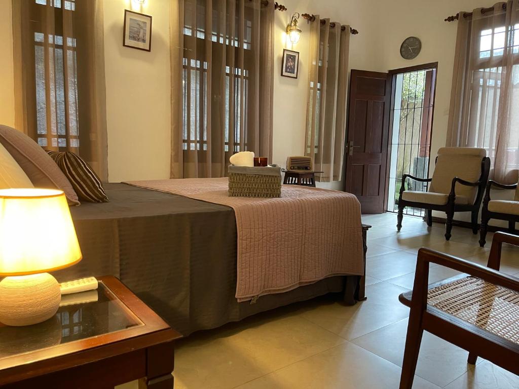a bedroom with a bed and a table with a lamp at The Manor 1926 in Colombo