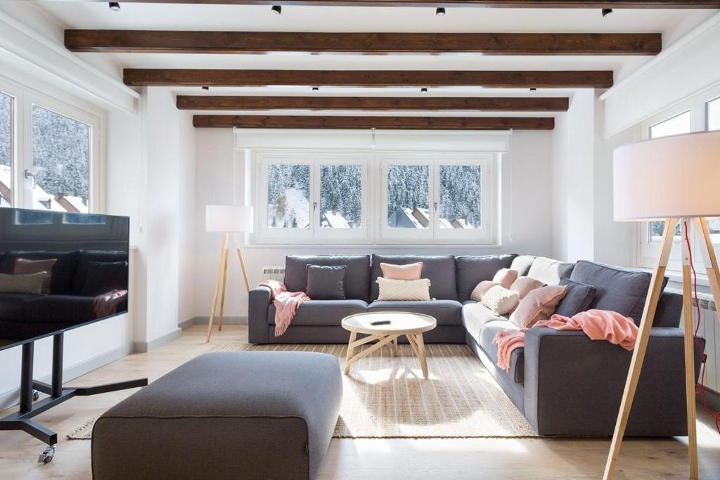 a living room with a couch and a table at Luderna - Apartamento con terraza Bonaigua B1 Joanchiquet in Baqueira-Beret