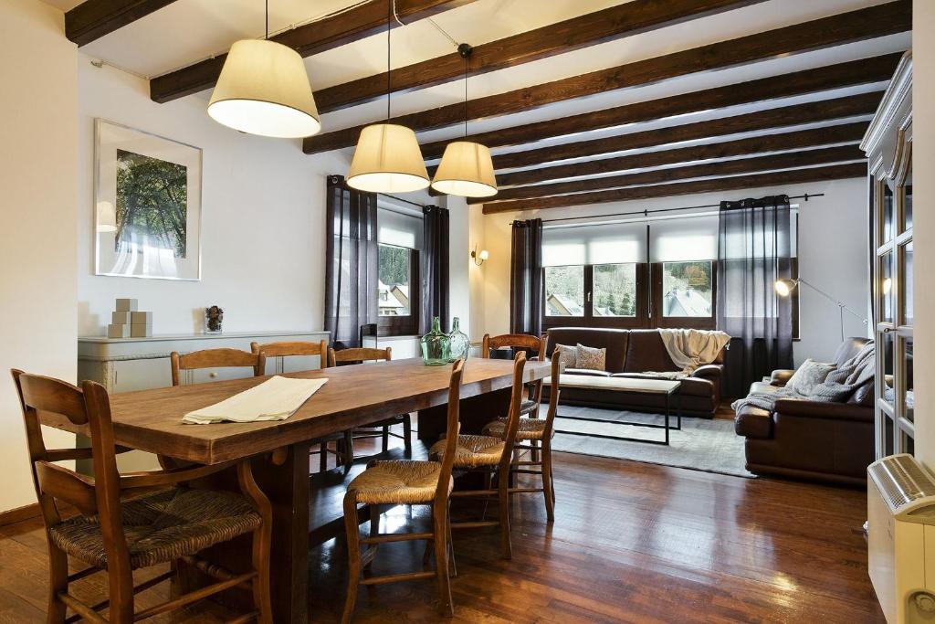 comedor y sala de estar con mesa de madera y sillas en Luderna - Apartamento con terraza Bonaigua B2 Salient, en Baqueira Beret