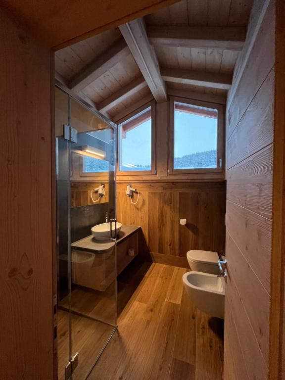 a bathroom with two sinks and a glass shower at Chalet Barbara in Livigno