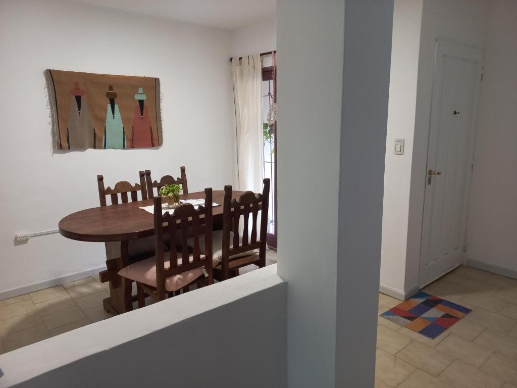 uma sala de jantar com uma mesa de madeira e cadeiras em Casa Luz em Neuquén