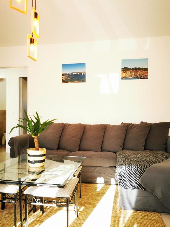 - un salon avec un canapé et une table en verre dans l'établissement Grand appartement a 300M de la plage, à Sainte-Maxime