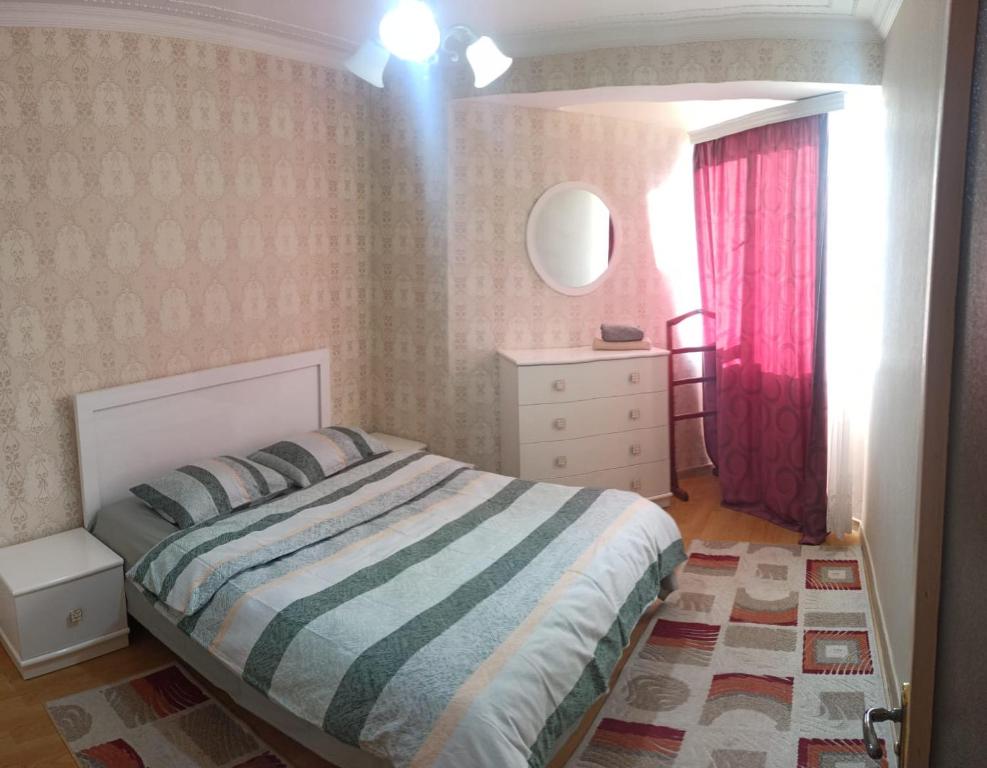 1 dormitorio con cama y cortina roja en Apartment in Tskaltubo - # 1 en Tskaltubo