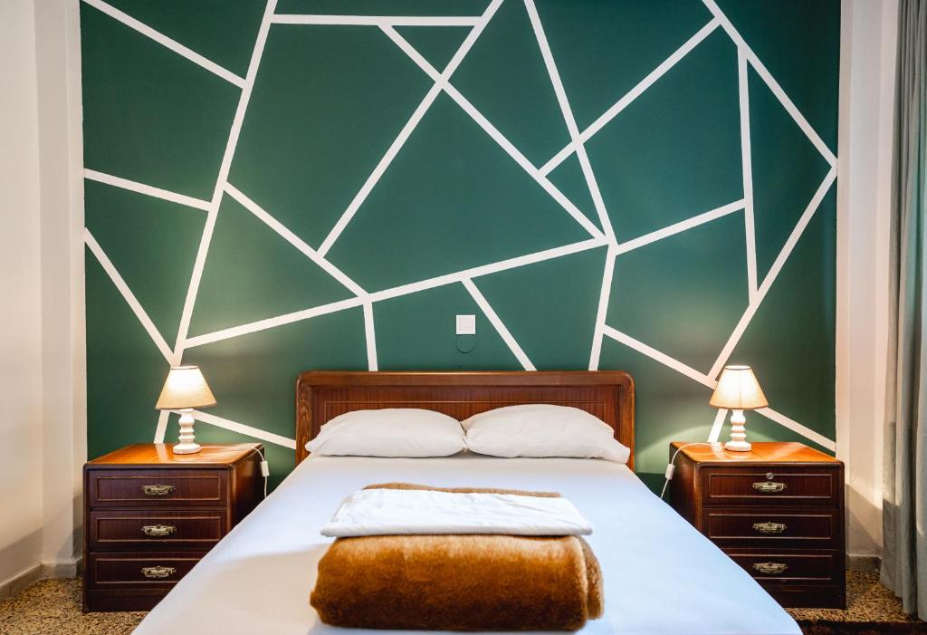 ein Schlafzimmer mit einer grünen Wand mit einem Bett und zwei Nachttischen in der Unterkunft Apartment 105 sq.m. near center in Patras