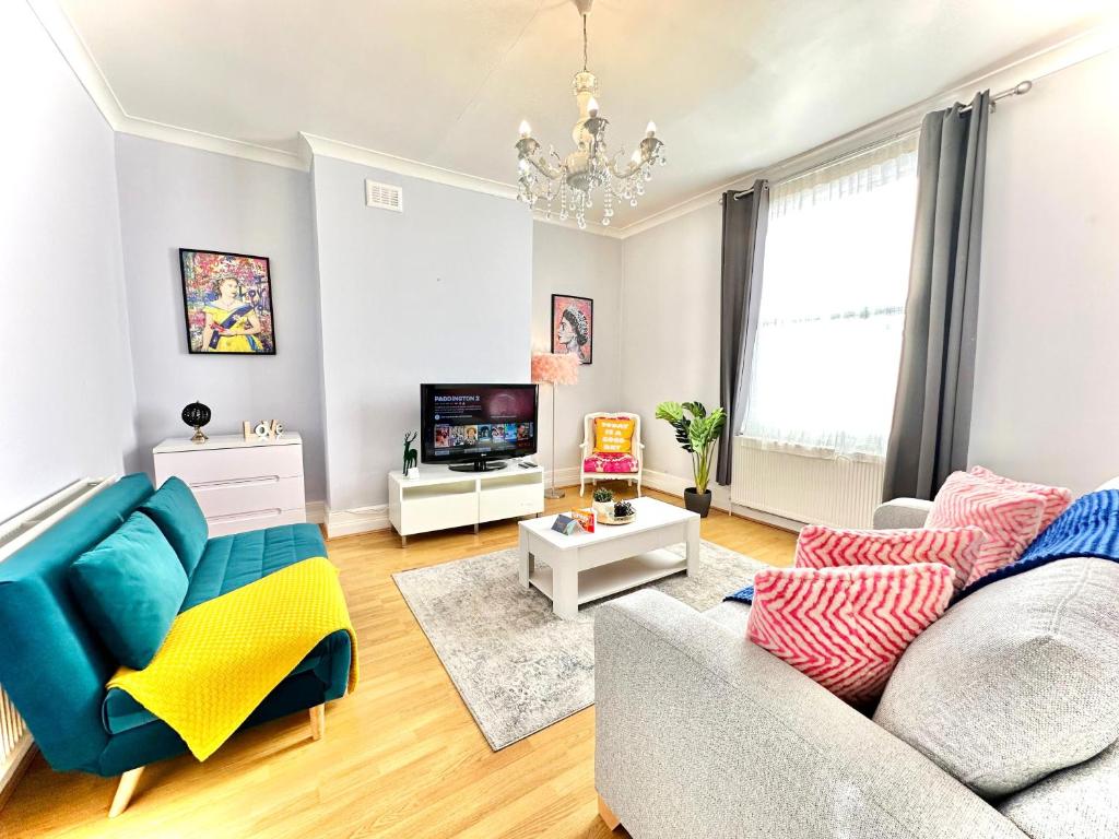 a living room with a couch and a tv at Enticing 2 Bed 2 Bath Flat in Hackney with garden in London