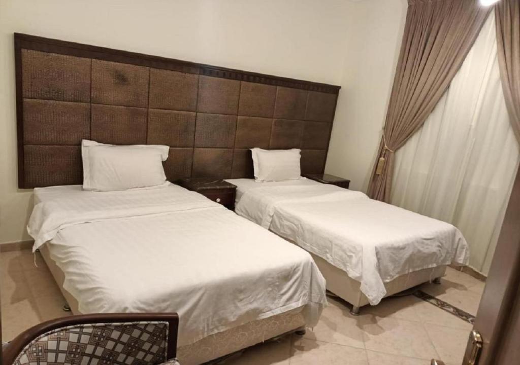 duas camas num quarto de hotel com lençóis brancos em فندق الافاق بالنسيم em Jeddah