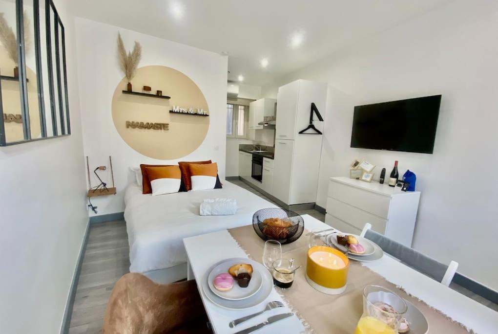 een woonkamer met een tafel met eten erop bij Le Kozy - Chambre hôtel en plein coeur de ville in Nîmes