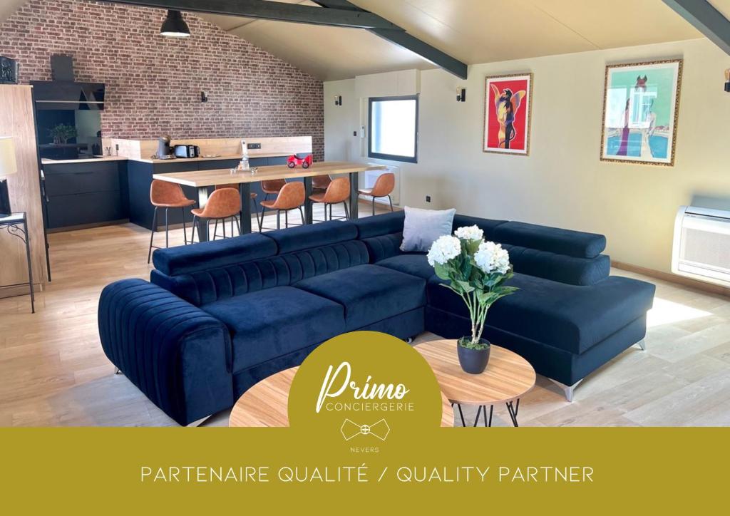 a living room with blue couches and a kitchen at Le Loft Manhattan, en centre ville, proche Sainte Bernadette avec Parking, PRIMO C0NCIERGERIE in Nevers