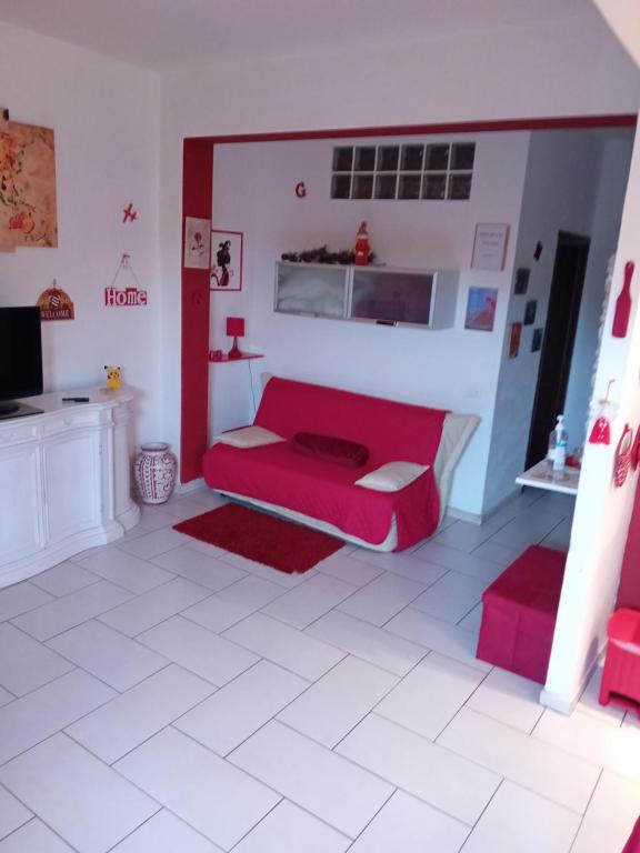 een woonkamer met een rode bank en een tv bij Dalla Rossa in Montelupo Fiorentino
