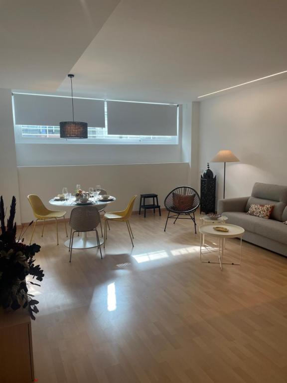 ein Wohnzimmer mit einem Tisch, Stühlen und einem Sofa in der Unterkunft Soho Moraleja I in Alcobendas