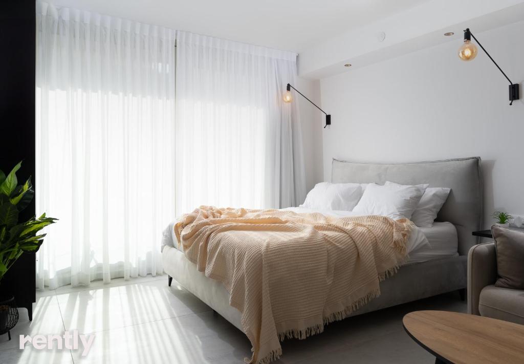 埃拉特的住宿－Sea side "lilac" apartment - by Rently，一间卧室设有一张床和一个大窗户