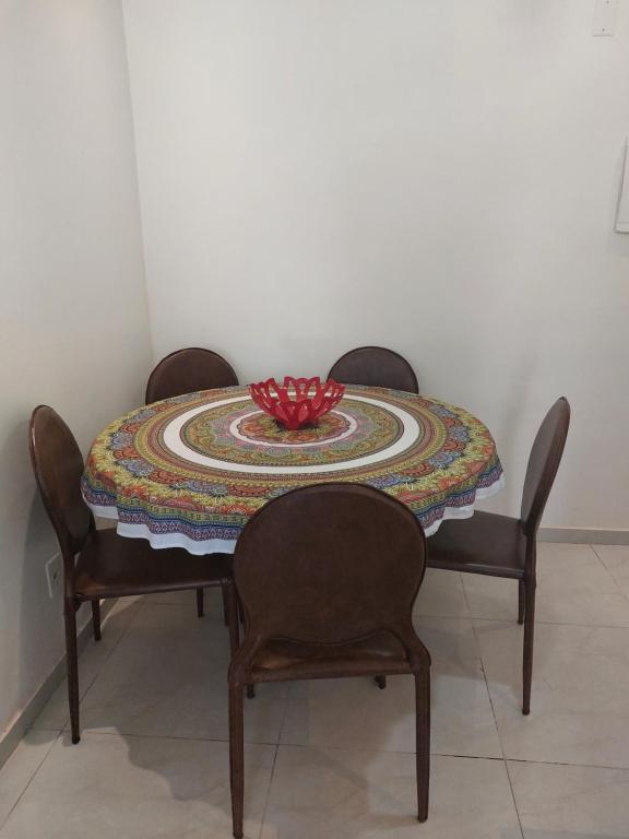 einen Tisch mit 2 Stühlen und eine Schüssel darüber in der Unterkunft #Apto a beira-mar na Praia do Sul de Ilhéus in Ilhéus