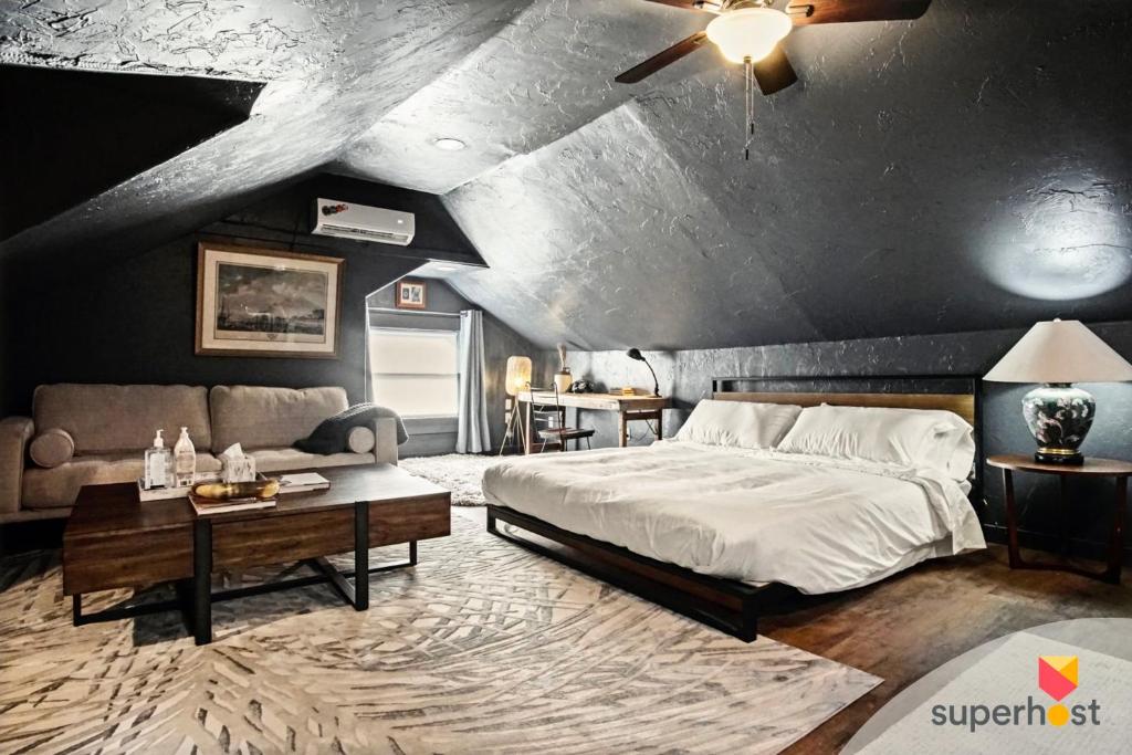 um quarto com uma cama grande e um sofá em Spring Sanctuary Stylish Haven Near Asian Dist em Oklahoma City