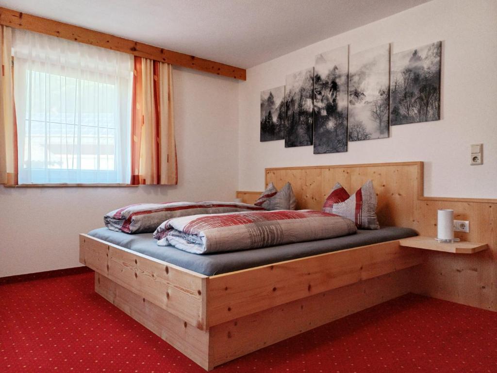 a bedroom with a wooden bed and a window at Haus Gstrein in Oetz