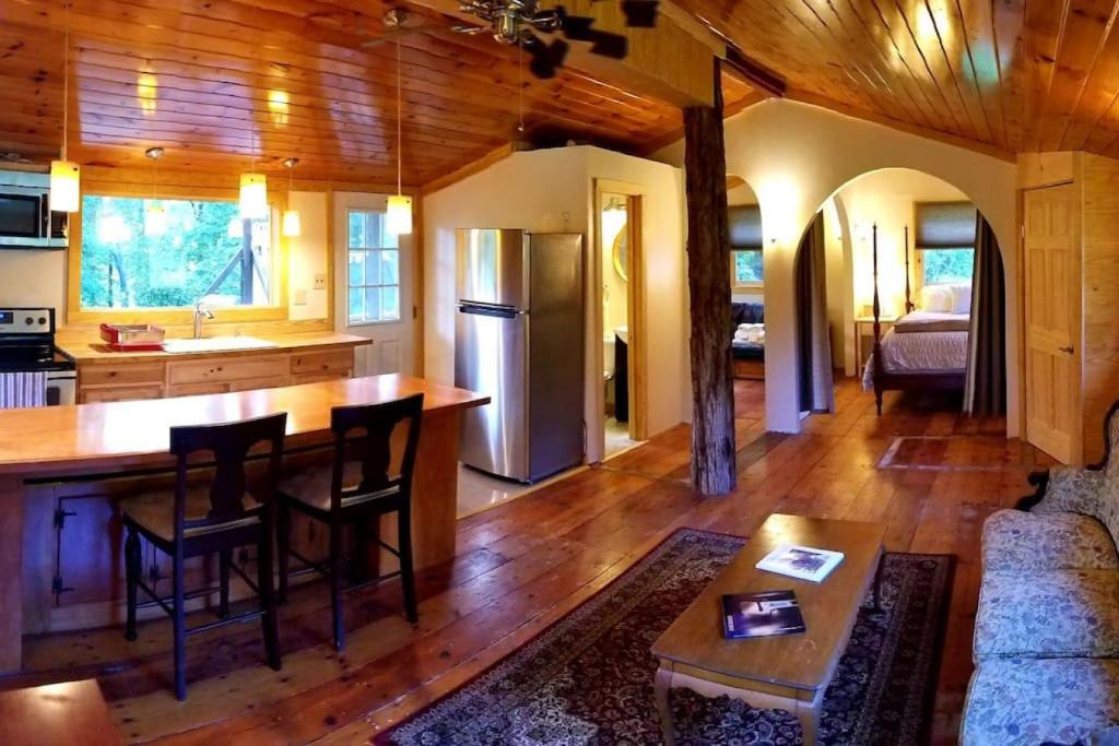 uma cozinha e sala de estar com uma mesa e um sofá em Farmview Cottage at White Lotus Eco Spa Retreat em Stanardsville