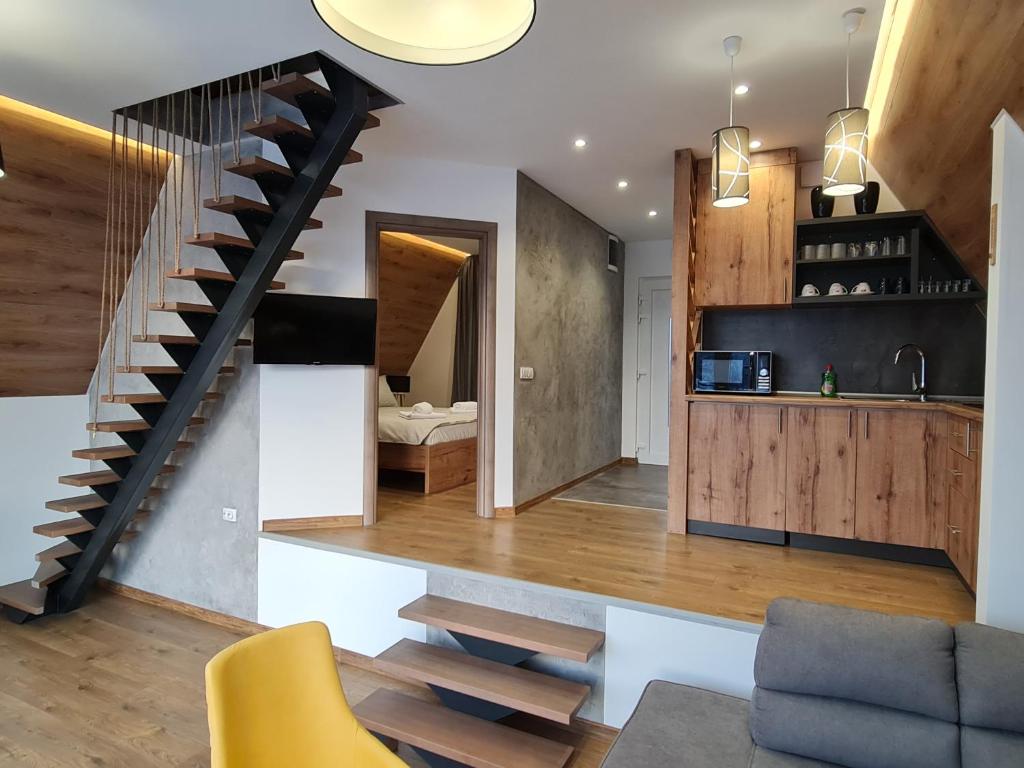 a kitchen and a living room with a spiral staircase at Bajkoviti bungalov in Pale
