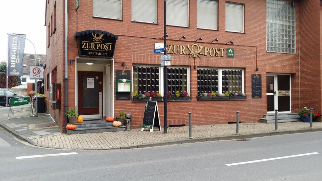 a brick building with a flower shop on the street at ZUR POST - HÜLCHRATH in Grevenbroich