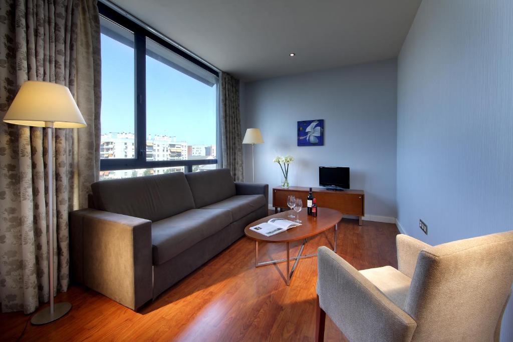 una sala de estar con un sofá y una mesa en Exe Sevilla Palmera, en Sevilla