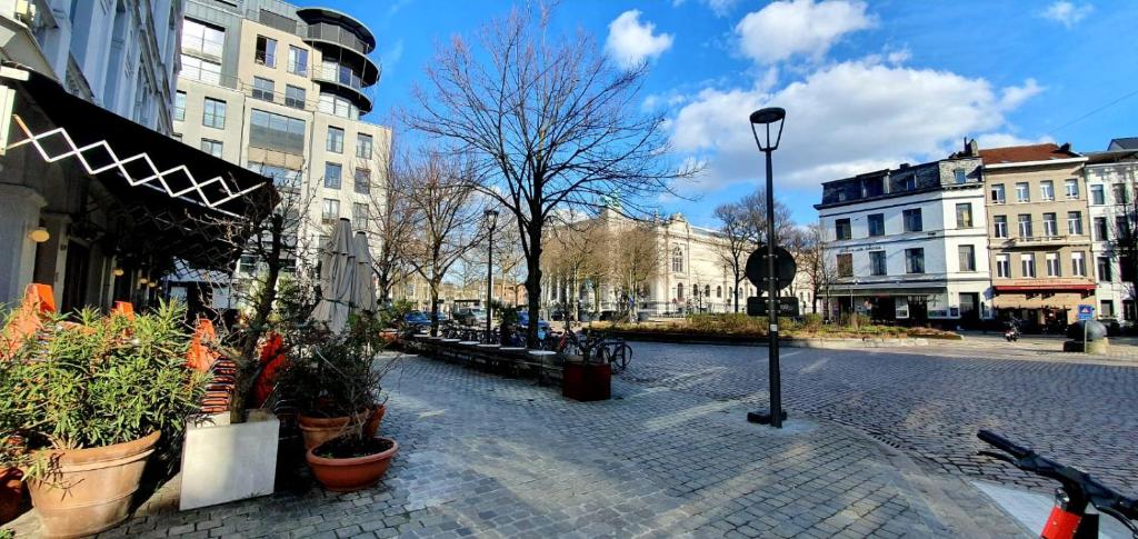 uma rua urbana com vasos de plantas e edifícios em The South Suite - trendy duplex op het Zuid em Antuérpia