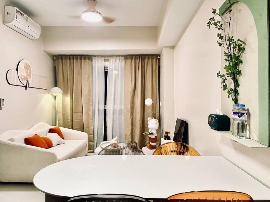 a living room with a white couch and a table at Thompson Suites - 2-beds near OKADA, Bayshore 2 in Manila