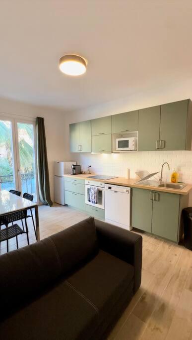 un salon avec un canapé et une cuisine dans l'établissement Charmant 3 pièces idéalement situé, à Menton