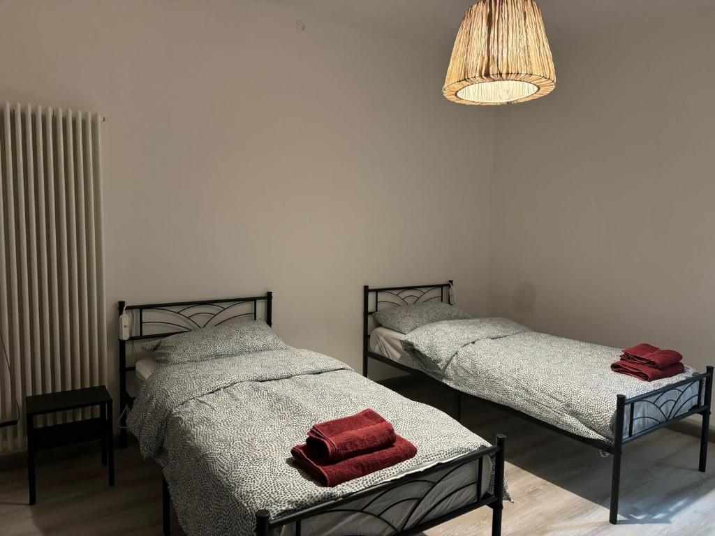 1 dormitorio con 2 camas y lámpara de araña en Lavanda House, en Vicenza