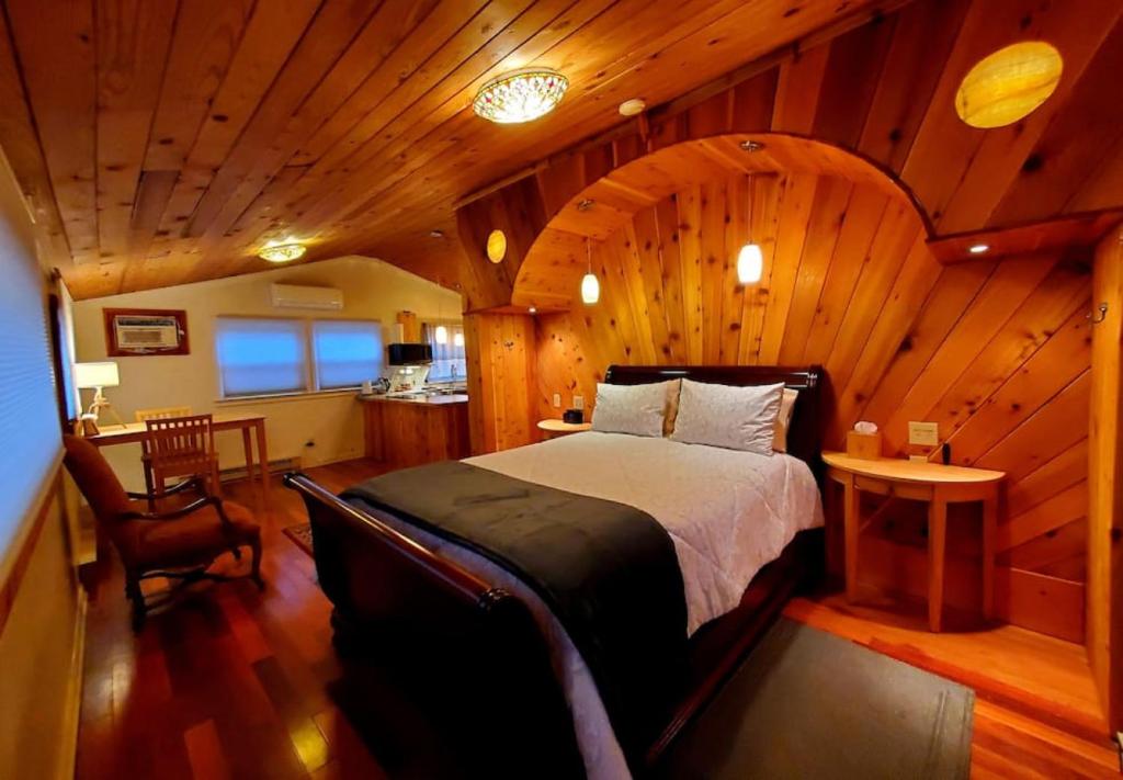 a bedroom with a large bed in a wooden room at Glade Cottage at White Lotus Eco Spa Retreat in Stanardsville
