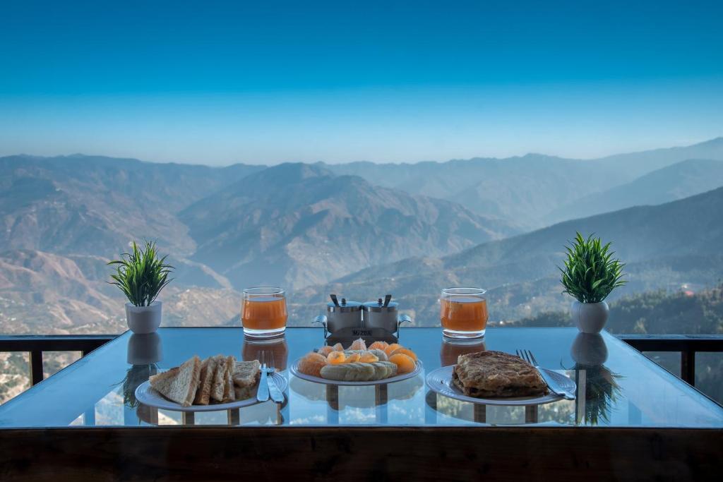 un tavolo con cibo e vista sulle montagne di KufriVista Mountain Lodge a Kūfrī