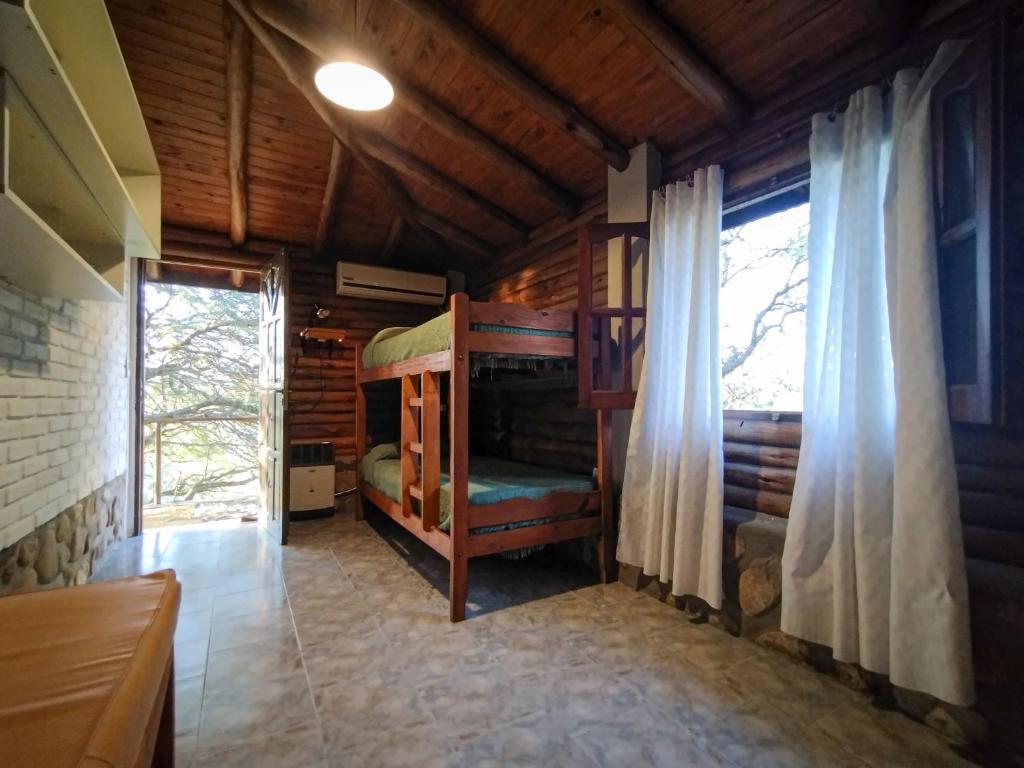 ein Schlafzimmer mit Etagenbetten in einem Holzhaus in der Unterkunft Cabaña de troncos en Nono, Córdoba in Nono