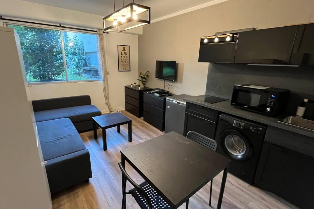 uma sala de estar com uma cozinha e uma sala de estar com uma mesa em Appartement Porte de Vincennes Nation - 2 pers em Saint-Mandé