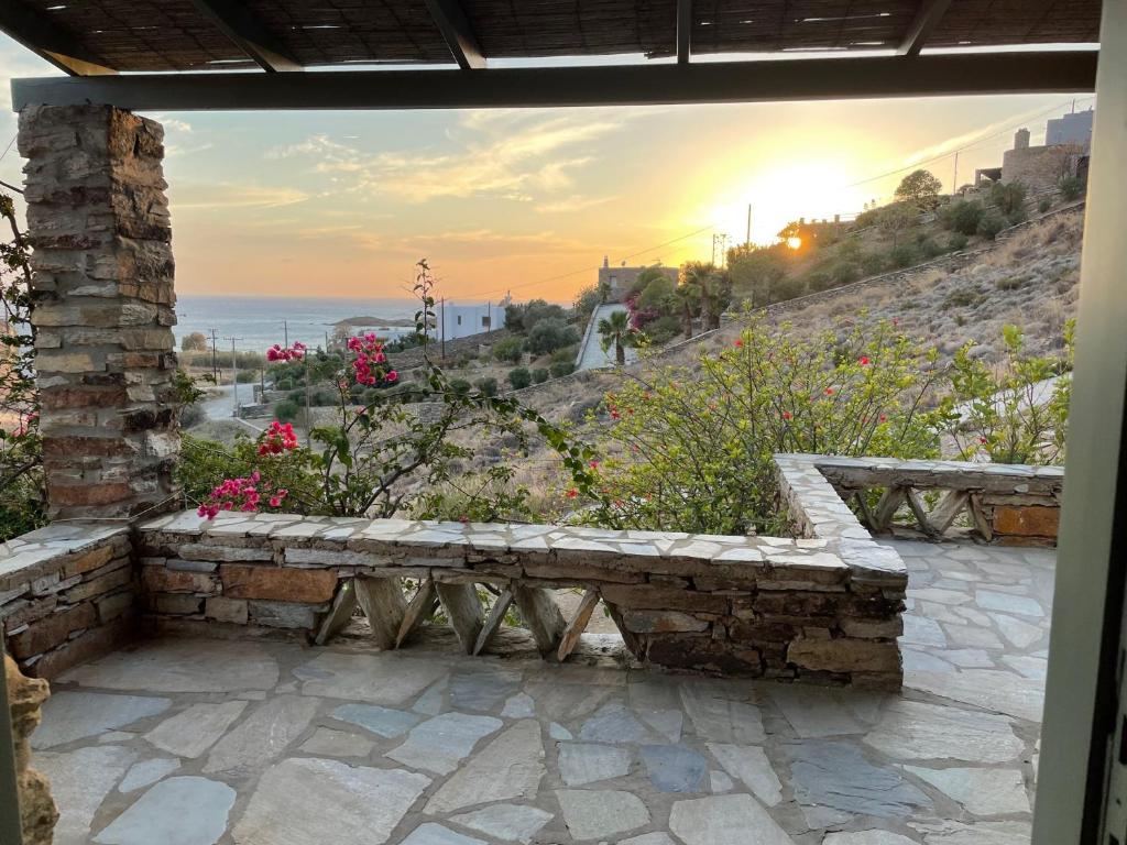 een stenen bank op een patio met uitzicht op de oceaan bij villa hibiscus with swimmimg pool see view few meters from beaches in Koundouros