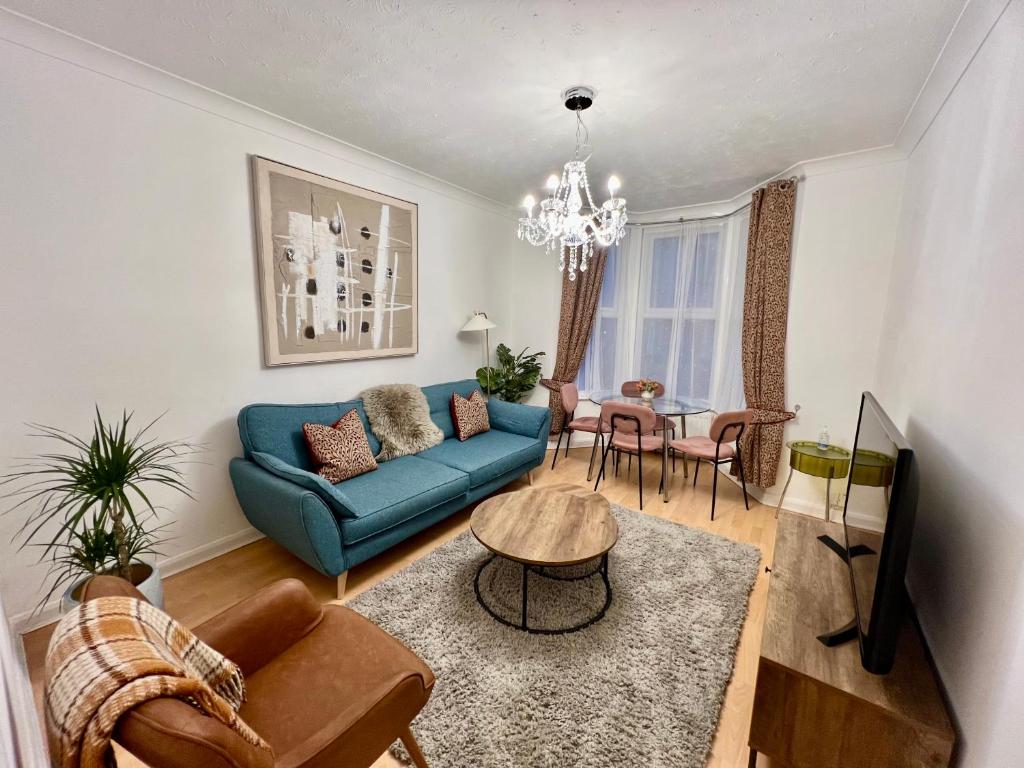 Una sala de estar con un sofá azul y una mesa. en Central Cambridge Fig Tree House, en Cambridge