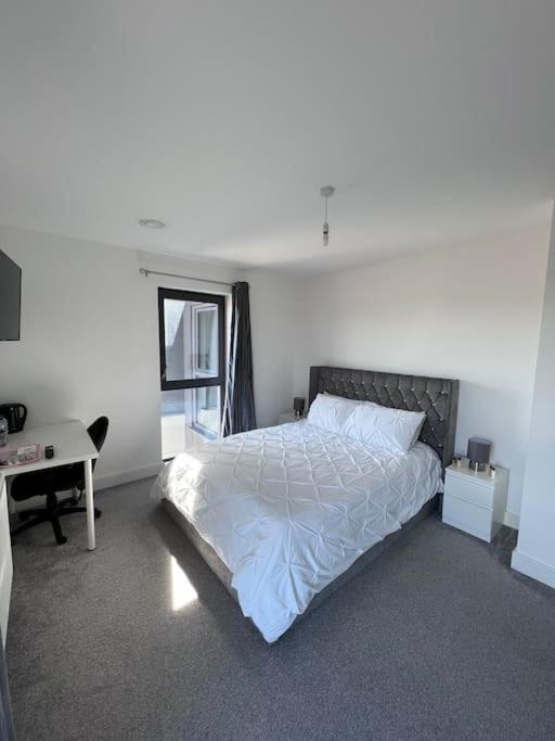 a white bedroom with a bed and a desk at Canterbury Penthouse: HUGE 2 bed ensuite + balcony in Canterbury