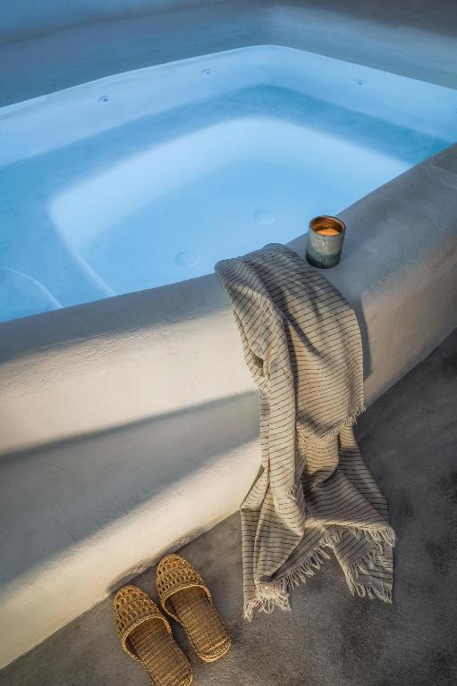 a pair of sandals sitting next to a swimming pool at Yposkafon Concept Two-Bedroom Villa with Private Jacuzzi and Hamam in Megalochori