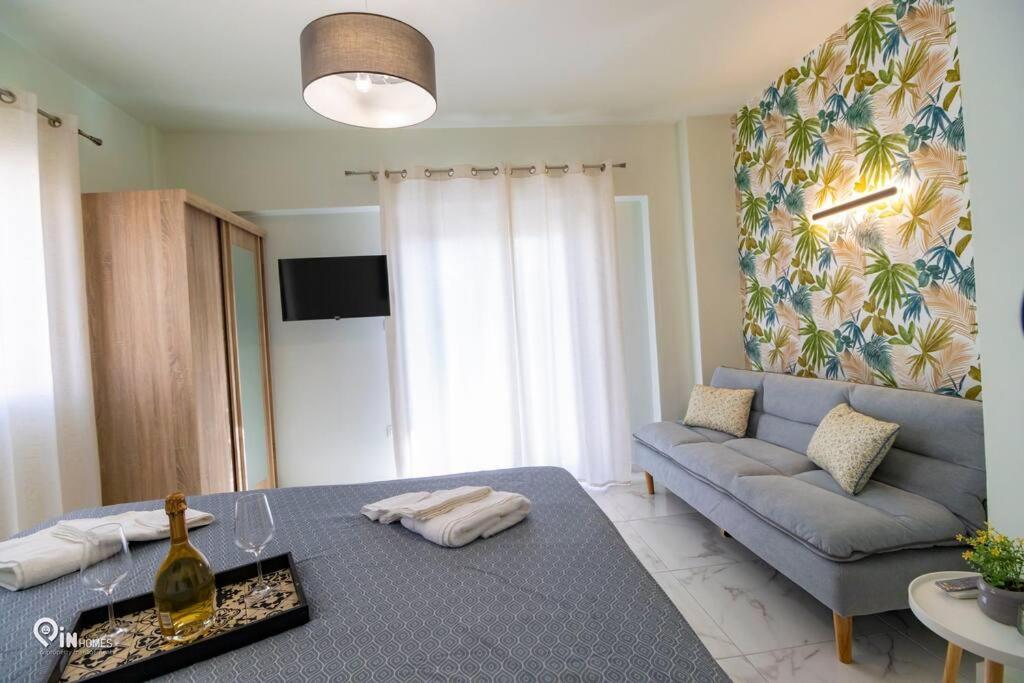 ein Wohnzimmer mit einem blauen Sofa und einem Tisch in der Unterkunft 'Ariadni' Elegant Residence in Athen