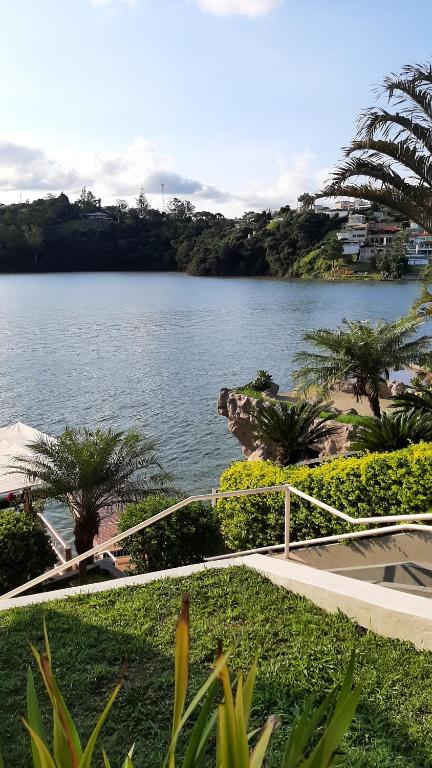 uma vista para um grande corpo de água com palmeiras em Farol das Aguas em Igaratá