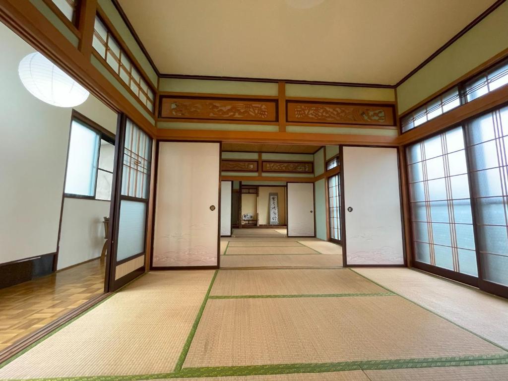 Habitación vacía con ventanas grandes y pasillo. en Tanonagano Yadokko - Vacation STAY 62252v, en Goshogawara