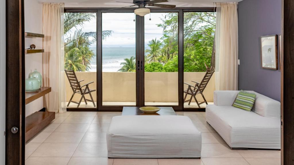a living room with a view of the ocean at Las Flores Resort in Chirilagua