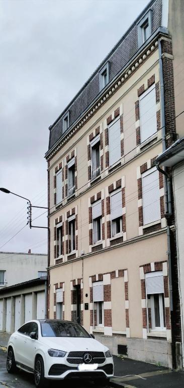 une voiture blanche garée devant un immeuble dans l'établissement ESCAPADE en CHAMPAGNE Moments conviviaux entre amis, famille, à Épernay