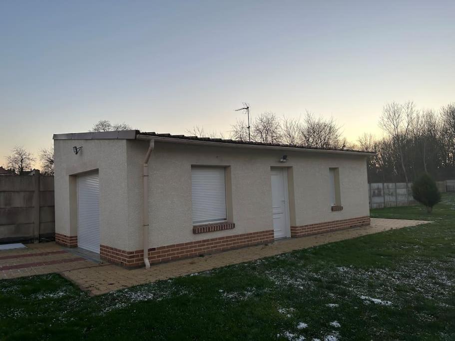 ein kleines Haus mit zwei Fenstern und einem Zaun in der Unterkunft Au Petit Faubourg in Roye