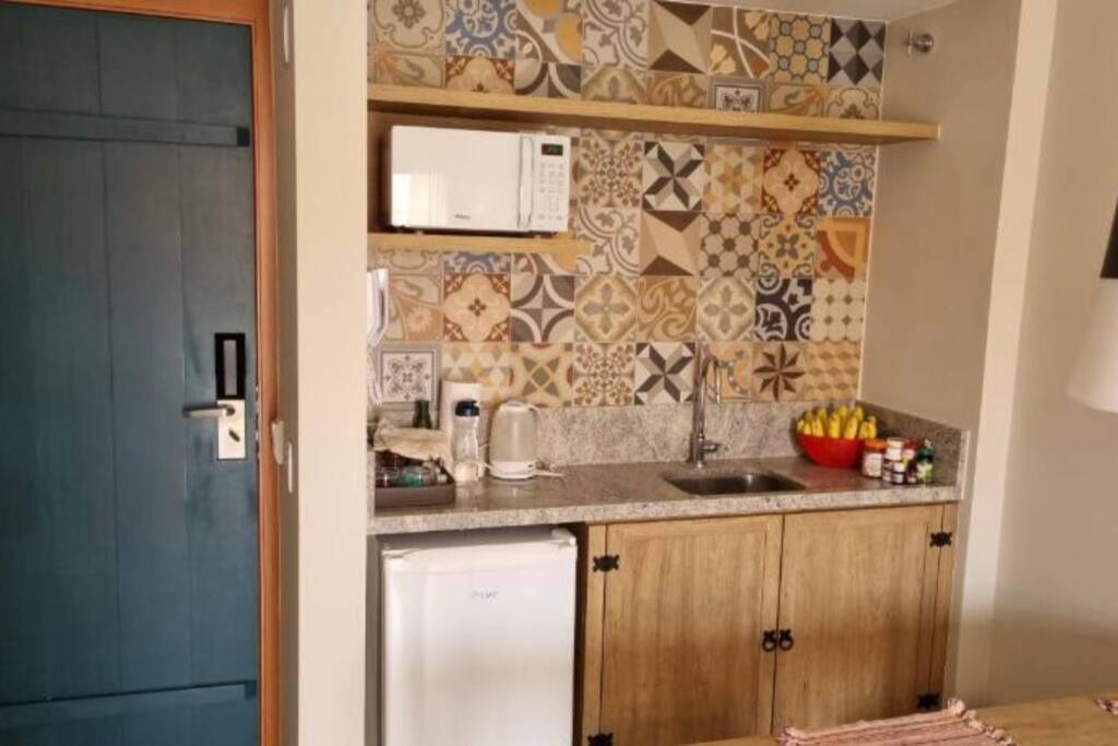 eine Küche mit einer Spüle und einer Theke in der Unterkunft Eco Resort Quinta Santa Bárbara Ap 101/11 bloco E in Pirenópolis
